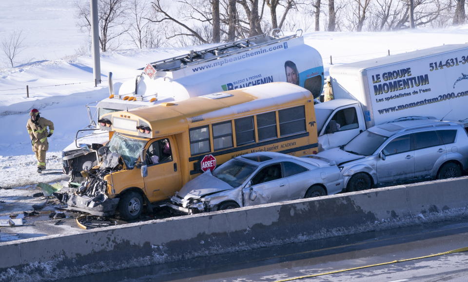 Emergency personnel gather at the scene following a multi-vehicle crash on the south shore of Montreal in La Prairie, Quebec, Wednesday, Feb. 19, 2020. (Paul Chiasson/The Canadian Press via AP)