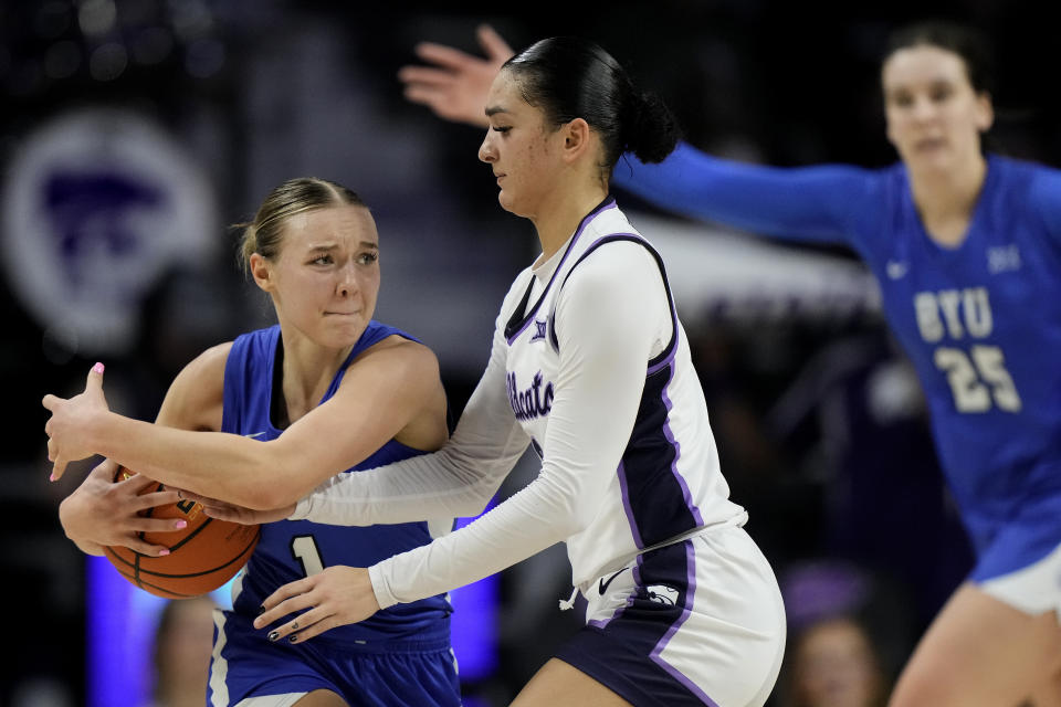 Kansas State guard Jaelyn Glenn, center, tries to steal the ball from BYU guard Amari Whiting (1) during the second half of an NCAA college basketball game Saturday, Jan. 27, 2024, in Manhattan, Kan. Kansas State won 67-65. (AP Photo/Charlie Riedel)