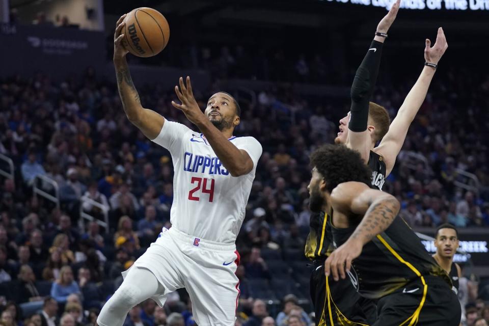 Clippers forward Norman Powell shoots against Golden State Warriors forward Anthony Lamb and guard Donte DiVincenzo.