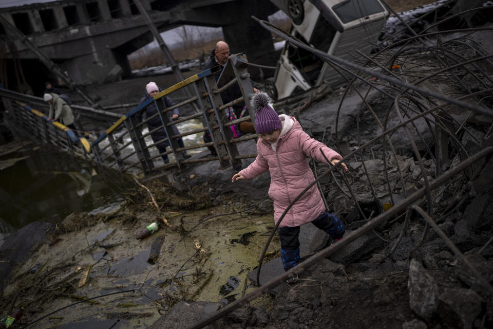 A girl walks as she is fleeing with her family across a destroyed bridge, on the outskirts of Kyiv, Ukraine, Wednesday, March 2. 2022. Russia renewed its assault on Ukraine’s second-largest city in a pounding that lit up the skyline with balls of fire over populated areas. That came Wednesday even as both sides said they were ready to resume talks aimed at stopping the new devastating war in Europe. (AP Photo/Emilio Morenatti)