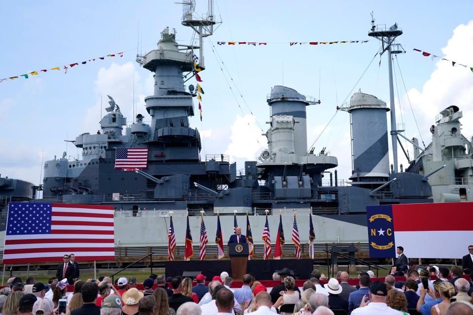 With the Battleship North Carolina in the background, President Donald Trump speaks during a ceremony to designate Wilmington as the first American World War II Heritage City on Wednesday. [AP Photo/Evan Vucci]