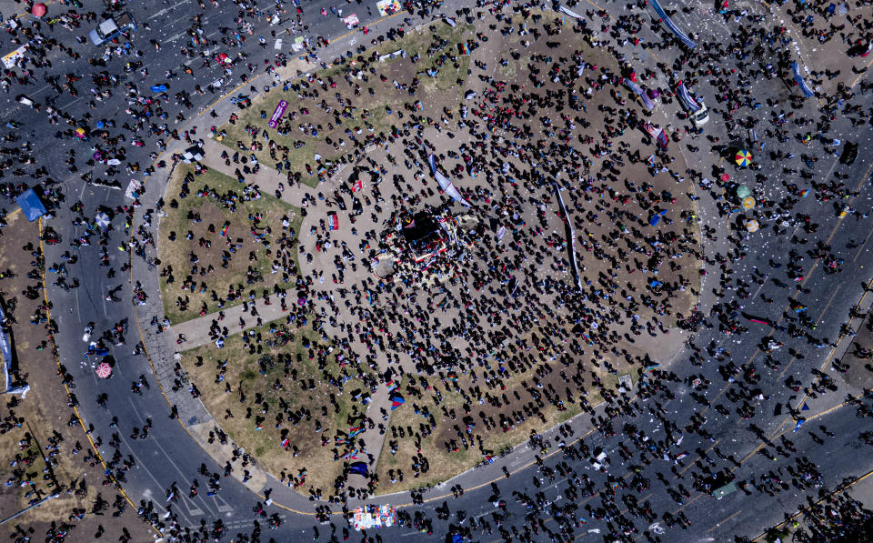 Manifestantes conmemoran el primer aniversario del inicio de protestas masivas contra el gobierno desencadenadas por el aumento de la tarifa del metro, que llevó a demandas de cambio social a nivel nacional, en la Plaza Italia, Santiago de Chile, el domingo 18 de octubre de 2020. (Foto AP/Esteban Félix)