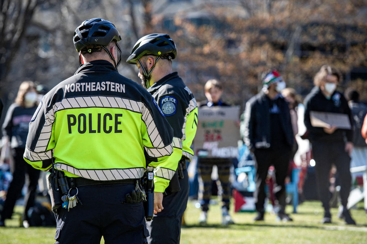 Police watch as pro-Palestinian protesters create a human chain around an encampment set up. (Joseph Prezioso / AFP - Getty Images)