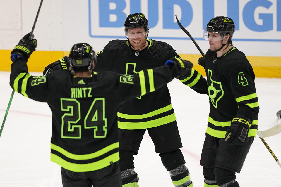 Dallas Stars' Roope Hintz (24), Joe Pavelski, center, and Miro Heiskanen (4), celebrate after Pavelski scored in the third period of an NHL hockey game against the Detroit Red Wings in Dallas, Monday, Dec. 11, 2023. (AP Photo/Tony Gutierrez)