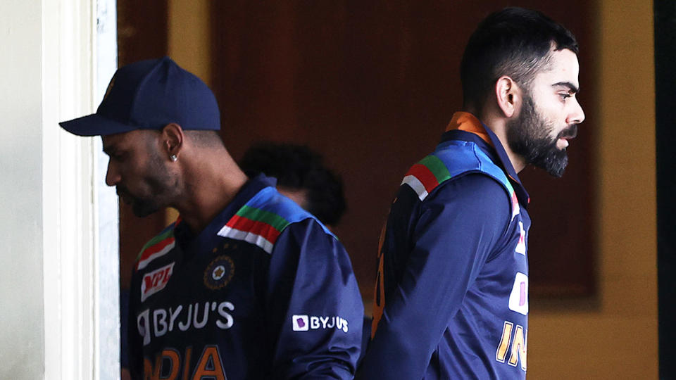 Virat Kohli (pictured right) walking past teammate Hardik Pandya (pictured left).