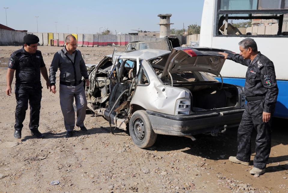 FILE - In this Thursday, Feb. 6, 2014 file photo, Iraqi security forces inspect a car destroyed after a car bomb attack in the Jamila neighborhood of Baghdad, Iraq. Car bombs are one of the deadliest weapons used by the al-Qaida breakaway group in Iraq that dominates the Sunni insurgency in Iraq, with coordinated waves of explosions regularly leaving scores dead in Baghdad and elsewhere across the country. (AP Photo/Karim Kadim, File)