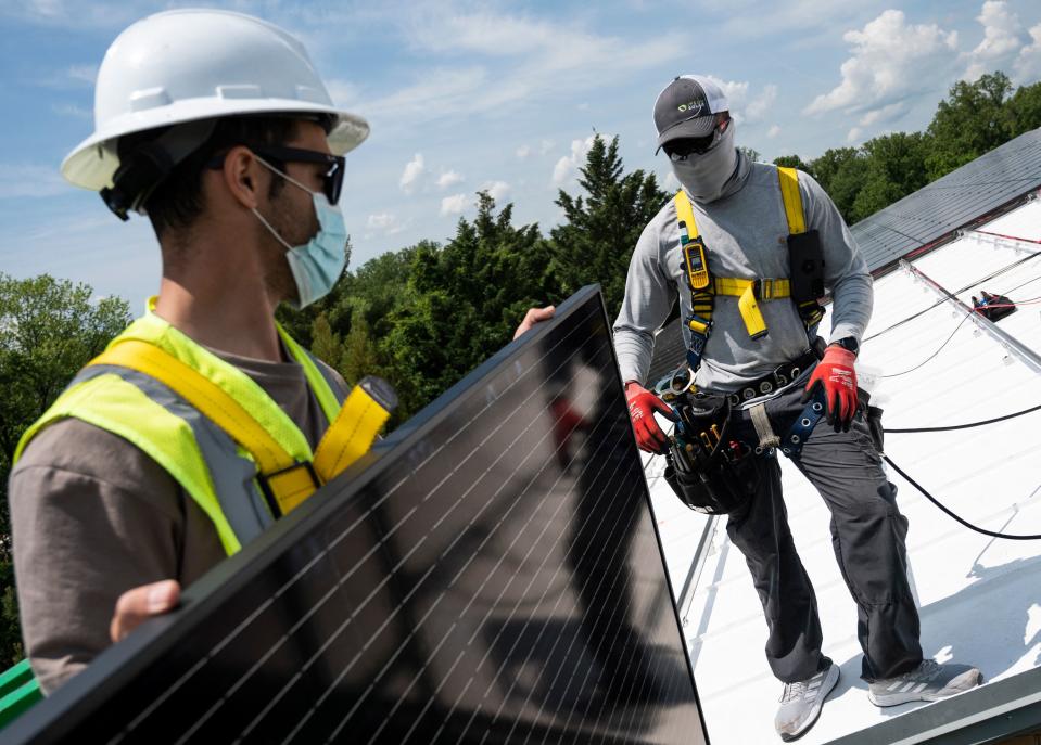 Employees with Ipsun Solar unload solar panels on the roof of the Peace Lutheran Church in Alexandria, Virginia on May 17, 2021. (Photo by Andrew CABALLERO-REYNOLDS/AFP) 