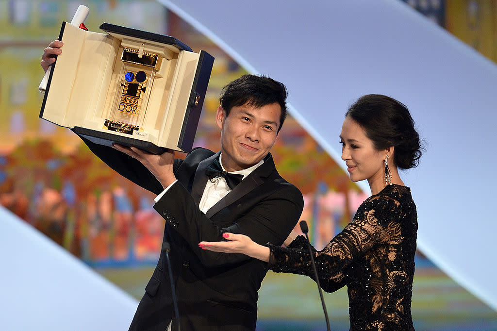 Singaporean director Anthony Chen (L) poses on stage on May 26, 2013 with Chinese actress and member of the Un Certain Regard Jury Zhang Ziyi after winning the Camera d'Or for Best First Film at the 66th Cannes film festival in Cannes.   AFP PHOTO / ALBERTO PIZZOLI        (Photo credit should read ALBERTO PIZZOLI/AFP/Getty Images)