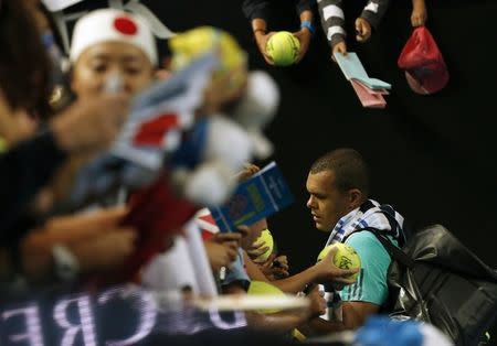 France's Jo-Wilfried Tsonga signs autographs after losing his fourth round match against Japan's Kei Nishikori at the Australian Open tennis tournament at Melbourne Park, Australia, January 24, 2016. REUTERS/Tyrone Siu