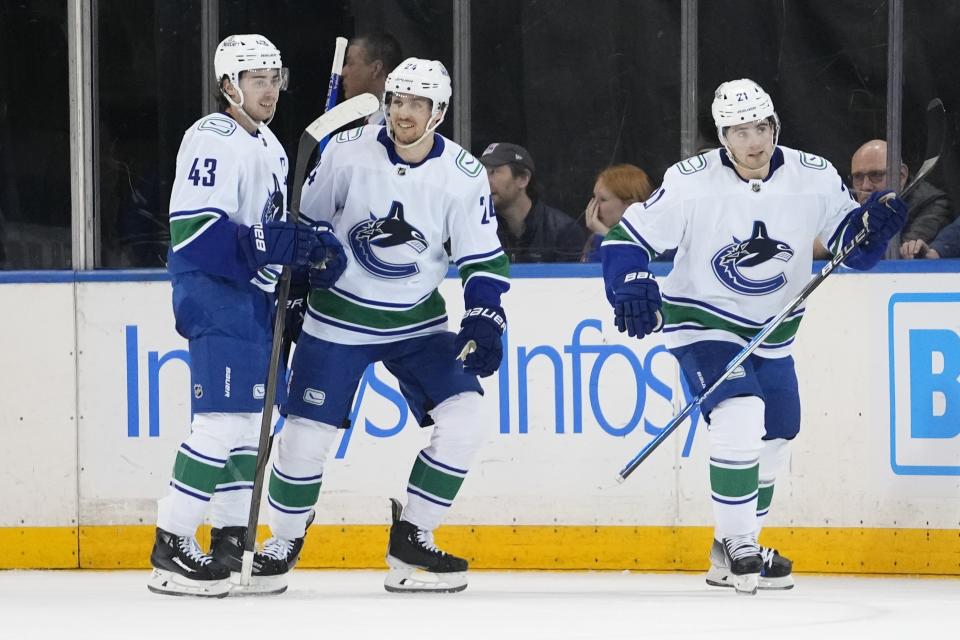 Vancouver Canucks' Nils Hoglander, right, skates back to the team bench with Pius Suter, center, and Quinn Hughes (43) after scoring a goal during the second period of an NHL hockey game against the New York Rangers Monday, Jan. 8, 2024, in New York. (AP Photo/Frank Franklin II)