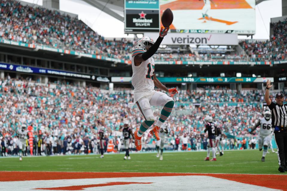 Miami Dolphins wide receiver Jaylen Waddle (17) flips the ball in the air as he scores a touchdown against the New England Patriots during the second half of an NFL game at Hard Rock Stadium in Miami Gardens, Oct. 29, 2023.