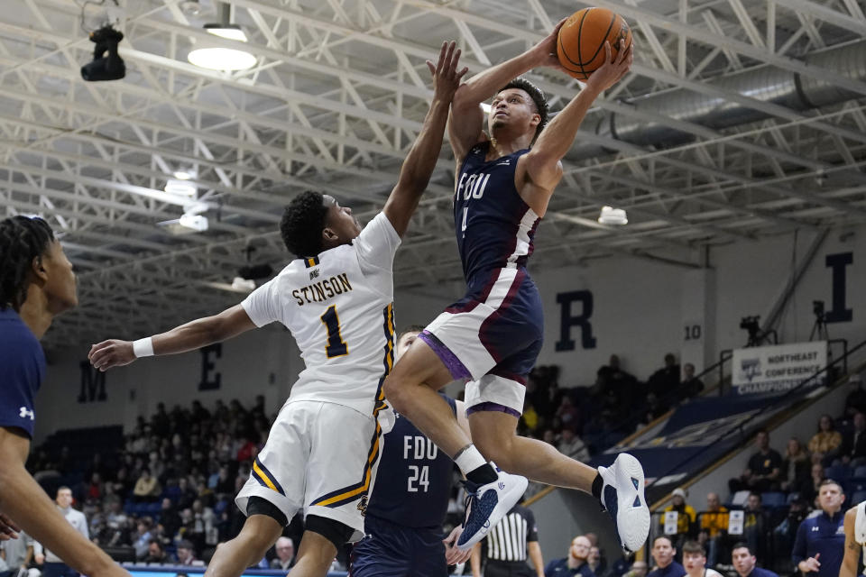 Fairleigh Dickinson guard Grant Singleton, right, drives to the basket against Merrimack guard Jaylen Stinson (1) during the first half of Northeast Conference men's NCAA college basketball championship game, Tuesday, March 7, 2023, in North Andover, Mass. (AP Photo/Charles Krupa)