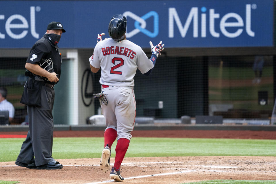 CORRECTS TO FOURTH INNING NOT THIRD INNING - Boston Red Sox's Xander Bogaerts (2) celebrates as he crosses the plate on a solo home run off Texas Rangers starting pitcher Mike Foltynewicz during the fourth inning of a baseball game Sunday, May 2, 2021, in Arlington, Texas. (AP Photo/Jeffrey McWhorter)