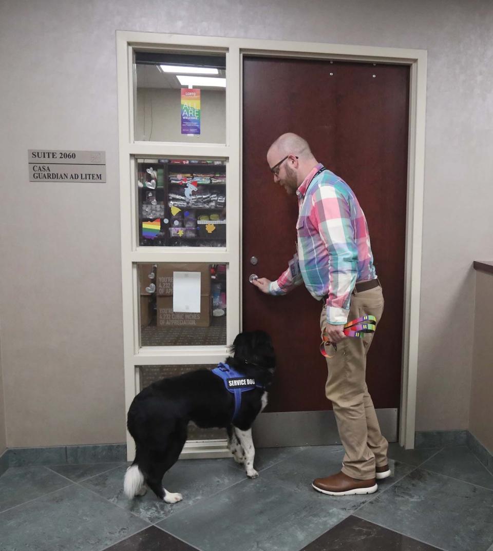 Geoff Auerbach and his dog, Tater Tot, the facility therapy dog at Summit County Juvenile Court, head to Auerbach's desk at the court.