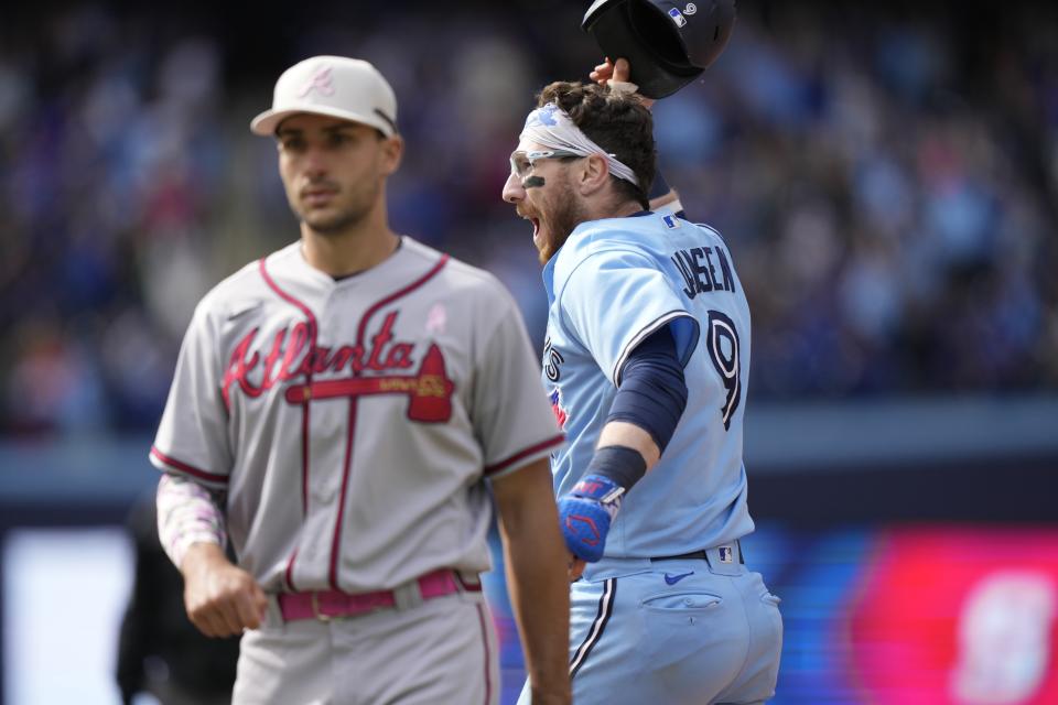 Toronto Blue Jays' Danny Jansen (9) celebrates as Atlanta Braves first baseman Matt Olson looks on after hitting a winning two-run single during ninth-inning baseball game action in Toronto, Ontario, Sunday, May 14, 2023. (Frank Gunn/The Canadian Press via AP)