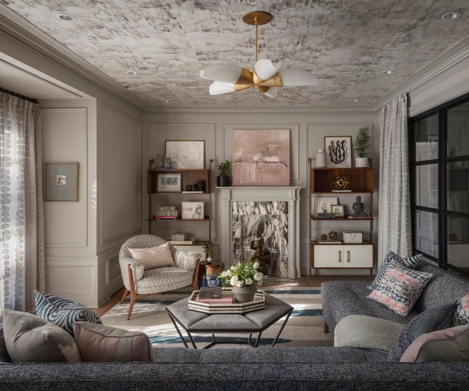 living room with dark neutral scheme and gray sectional sofa and marble fireplace