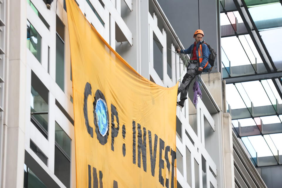 Activists from Animal Rebellion unfurl a banner after scaling the outside of the Department for Environment, Food and Rural Affairs (Defra) in Westminster, central London, calling for the Government to invest in a plant-based future at the upcoming Cop26 conference in Glasgow. Picture date: Tuesday October 26, 2021.