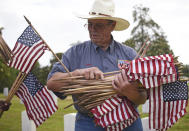 <p>Doug McCallister passes out U.S. flags Saturday, May 26, 2018 for volunteers to place in front of the tombstones at the Natchez National Cemetery in Natchez, Miss., as the community honors those who died in service to their country. (Photo: Nicole Hester/The Natchez Democrat via AP) </p>