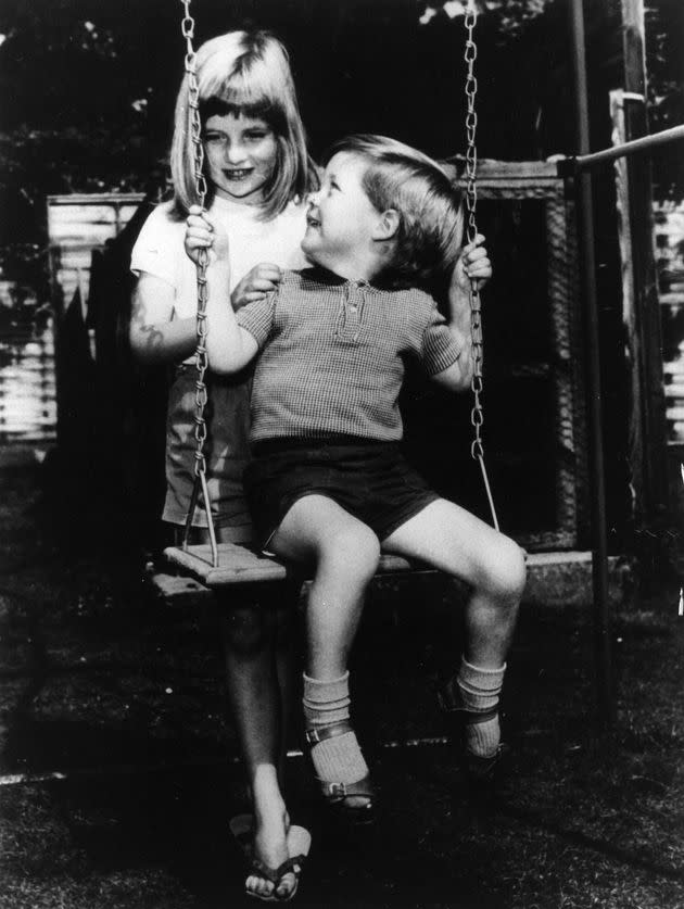 Another childhood photograph of Diana and Charles playing on a swing.