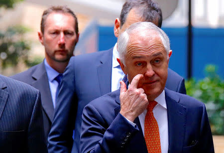 Australian Prime Minister Malcolm Turnbull reacts as he walks with officials and security personnel to a media conference announcing Australia's national security plan to protect public places in central Sydney, Australia, August 20, 2017. REUTERS/David Gray