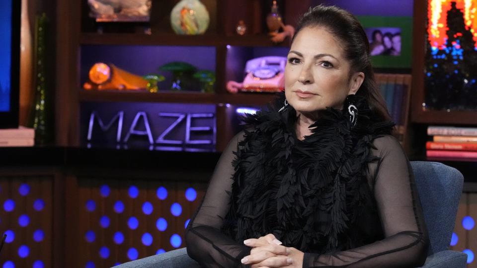 gloria estefan sitting in a guest chair with her hands folded across her lap