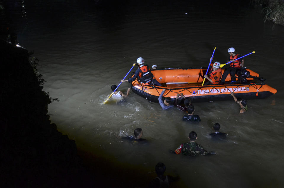 Rescuers search for victims of drowning in a river in Ciamis, West Java, Indonesia, Friday, Oct. 15, 2021. A number of students drowned during a school outing for a river cleanup on Friday evening in Indonesia's West Java Province. (AP Photo/Yopi Andrias)