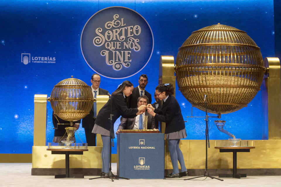 Alumnos de la escuela San Ildefonso de Madrid cantan el número ganador del sorteo de Lotería de Navidad española en el Teatro Real de Madrid, el domingo 22 de diciembre de 2019. (AP Foto/Paul White)