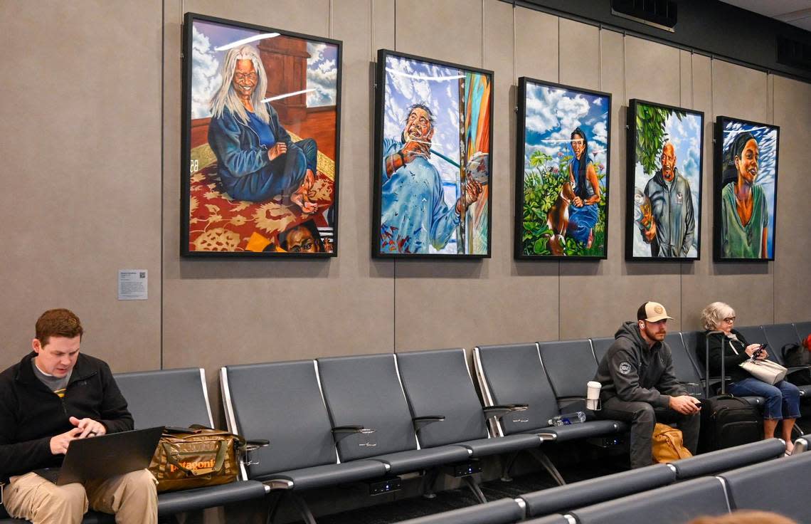 Travelers wait to board beneath People of KC, artwork by Kwanza Humphrey, installed in new $1.5 billion single terminal at Kansas City International Airport opened to travelers Tuesday, Feb. 28, 2023.