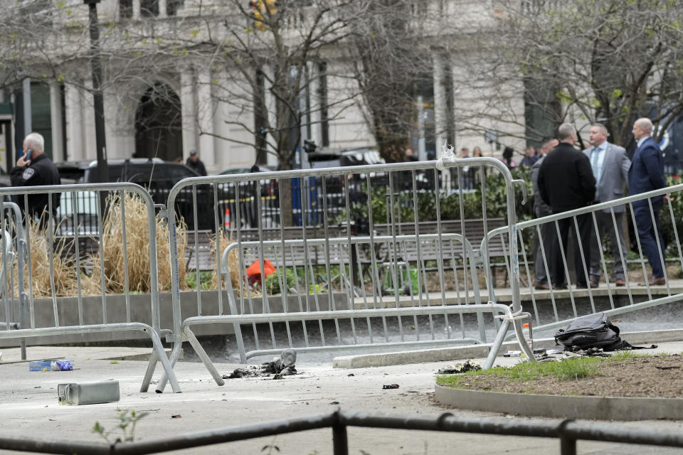 New York law enforcement and fire department personnel inspect the scene where a man lit himself on fire in a park outside Manhattan criminal court, Friday, April 19, 2024, in New York. Emergency crews rushed away a person on a stretcher after fire was extinguished outside the Manhattan courthouse where jury selection was taking place Friday in Donald Trump's hush money criminal case. (AP Photo/Mary Altaffer)