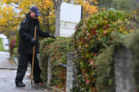 Police officers search bushes at the scene on Russell Way in Crawley, West Sussex, after a 24-year-old man was fatally stabbed on Tuesday night.