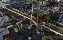 An aerial view of subway cars dangle at an angle from a collapsed elevated section of the metro, in Mexico City, Tuesday, May 4, 2021. The elevated section of Mexico City's metro collapsed late Monday killing at least 23 people and injuring at least 79, city officials said. (AP Photo/Fernando Llano)