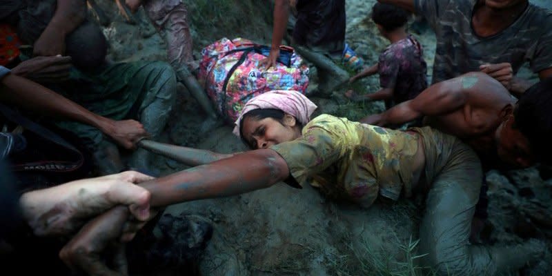 Photographers help a Rohingya refugee to come out of Naf River as they cross the Myanmar-Bangladesh border in Palong Khali, near Cox's Bazar, Bangladesh, November 1, 2017.  REUTERS/Hannah McKay