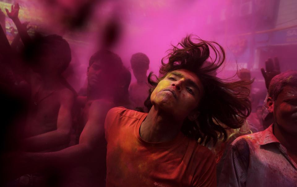 Indians, faces smeared with colored powder, dance during celebrations marking Holi, the Hindu festival of colors, in Gauhati, India, Monday, March 17, 2014. The festival also marks the advent of spring. (AP Photo/Anupam Nath)