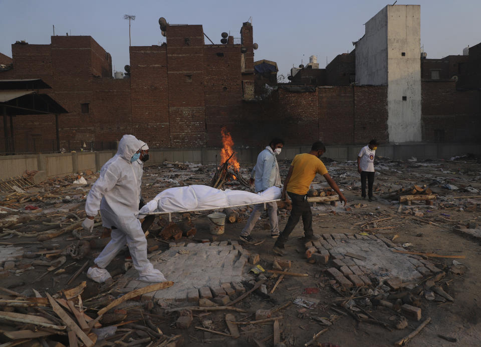 FILE - In this May 11, 2021, file photo, family members and volunteers carry the body of a COVID-19 victim for cremation in New Delhi, India. The capital of New Delhi is seeing some improvement in the fight against the coronavirus, but experts say the crisis is far from over in the country of nearly 1.4 billion people. Hospitals are still overwhelmed and officials are struggling with short supplies of oxygen and beds. (AP Photo/Amit Sharma)