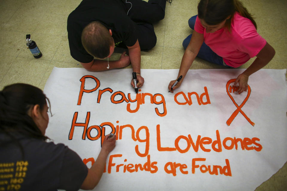 Darrington High School students make posters in the wake of Saturday's mudslide on Highway 530 in Snohomish County, Monday, March 24, 2014. The search for survivors of Saturday's deadly mudslide grew Monday to include scores of people who were still unaccounted for as the death toll from the wall of trees, rocks and debris that swept through the rural community rose to at least 14. (AP Photo/seattlepi.com, Joshua Trujillo)