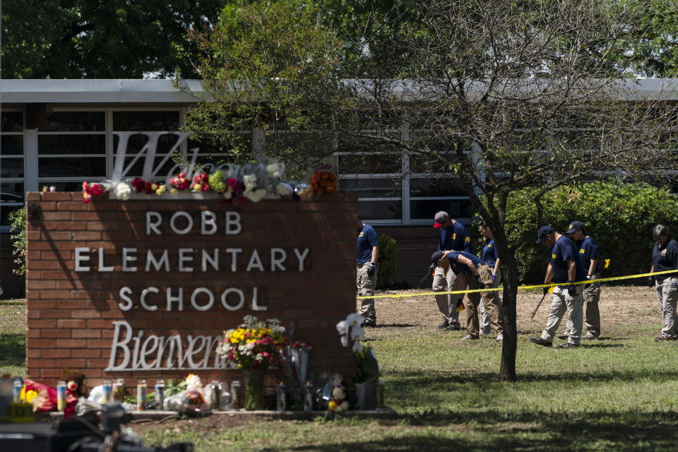 FILE - Investigators search for evidences outside Robb Elementary School in Uvalde, Texas, Wednesday, May 25, 2022. A gunman fatally shot 19 children and two teachers at the school the day before on May 24. Over an hour passed from the time officers followed the 18-year-old gunman into the school and when they finally entered the fourth grade classroom where he was holed up and killed him. Meanwhile, students trapped inside repeatedly called 911 and parents outside the school begged officers to go in. On July 17, 2022, a damning report on the response was released by an investigative committee from the Texas House of Representatives as well as hours of body camera footage, further laying bare the chaotic response that included 376 officers. (AP Photo/Jae C. Hong, File)