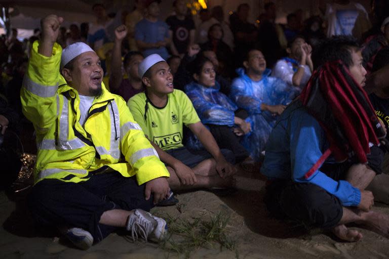 Supporters gesture as Malaysian opposition leader Anwar Ibrahim speaks on April 10, 2013