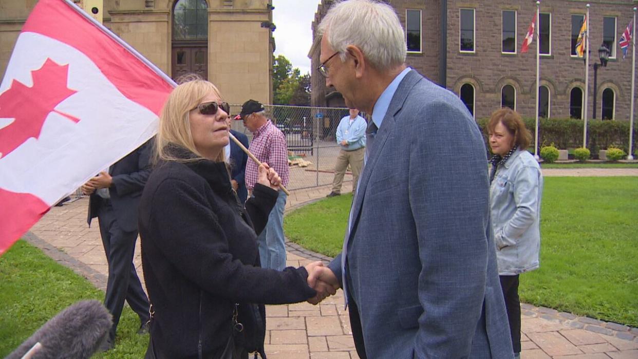 Higgs waded into a crowd about 250 people on the front lawn of the legislature, shaking hands with people carrying signs denouncing sex education and LGBTQ rights. (Ed Hunter/CBC - image credit)