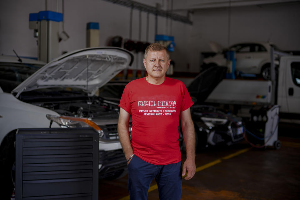 Giuseppe Monticelli poses in his car repair shop in Castelnuovo Vomano, near Teramo in central Italy, Sunday, June 4, 2023. While his wife takes their children to Mass regularly, he prefers to spend his little leisure time walking by the nearby beaches. (AP Photo/Domenico Stinellis)