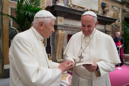 Former pope Benedict (L) is greeted by Pope Francis during a ceremony to mark his 65th anniversary of ordination to the priesthood at the Vatican June 28, 2016. Osservatore Romano/Handout via Reuters