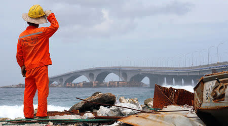 A construction worker looks on as the China-funded Sinamale bridge is seen in Male, Maldives September 18, 2018. REUTERS/Ashwa Faheem