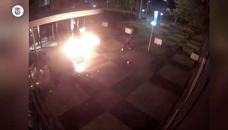 A still image taken from a video shot on June 26, 2018, shows a burning van and a man running after crashing into the glass facade of the head office of Dutch newspaper De Telegraaf in what police said was a deliberate action in Amsterdam, Netherlands June 26, 2018. REUTERS/via Reuters TV