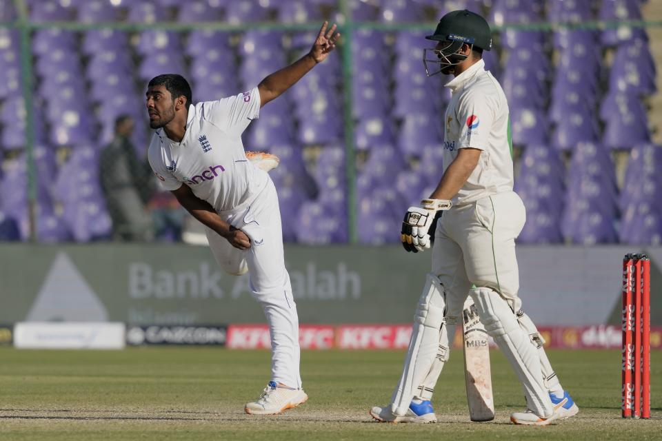 England's Rehan Ahmed, left, bowls during the third day of third test cricket match between England and Pakistan, in Karachi, Pakistan, Monday, Dec. 19, 2022. (AP Photo/Fareed Khan)