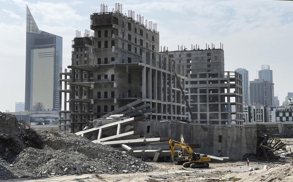 Workers demolish the abandoned Dubai Pearl high-rise project in Dubai, United Arab Emirates, Jan. 23, 2023. For the first time since a 2009 financial crisis nearly brought Dubai to its knees, several major abandoned real estate projects now show signs of life. As with its other booms, war again is driving money into Dubai and buoying its economy. This time it's Russian investors fleeing Moscow’s war on Ukraine, rather than people escaping Mideast battlefields. (AP Photo/Jon Gambrell)