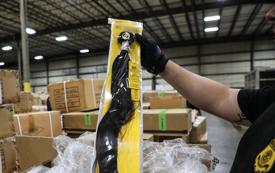 Officers of Customs and Border Protection inspect a shipment of hair pieces and accessories from China suspected to have been made with forced labor in June 2020 at the port of New York/Newark. (U.S. Customs and Border Protection)