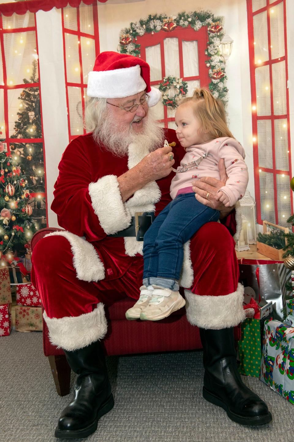 Larry Bennett, AKA "Santa," visits with Emily Kate Bassett at the Ronald McDonald House in Pensacola on Wednesday, Dec. 13, 2023. Bennett has been taking on the role of Santa at the house for sick kids and their families for the last eight years.