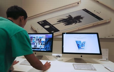 A sales assistant shows features of iOS 9 on an Apple iMac at an Apple reseller shop in Bangkok September 18, 2015. REUTERS/Chaiwat Subprasom