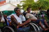 Tricycle drivers attend an outdoor movie screening held by a private organization in Phnom Penh