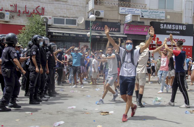 Manifestantes ante varios policías tunecinos durante una protesta en Túnez, capital de Túnez, el domingo 25 de julio de 2021