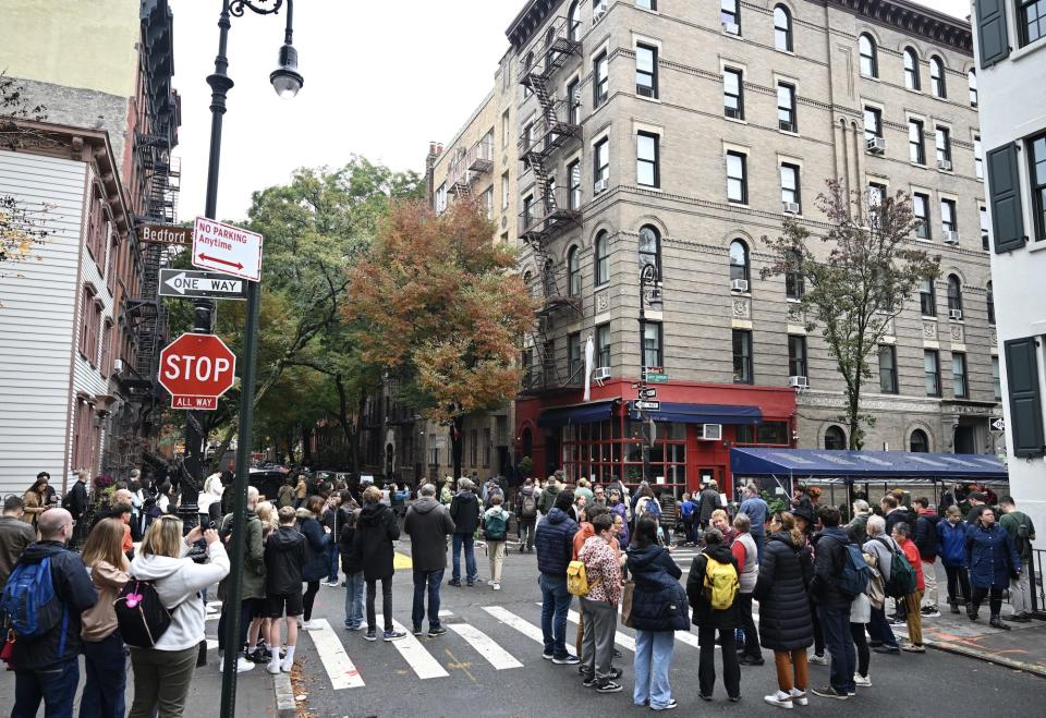 People gather to place flowers in front of the building known as the 'Friends apartment' following the death of 54-year-old actor Matthew Perry, known for his role as 'Chandler Bing' in the TV series named 'Friends', in New York, United States on October 30, 2023.